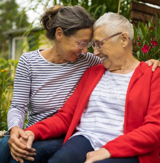 Senior woman with caregiver in the garden