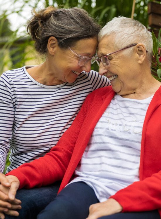 Senior woman with caregiver in the garden