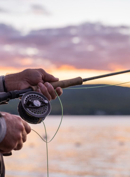 Senior Man Fly-Fishing at Sunset at the lake.