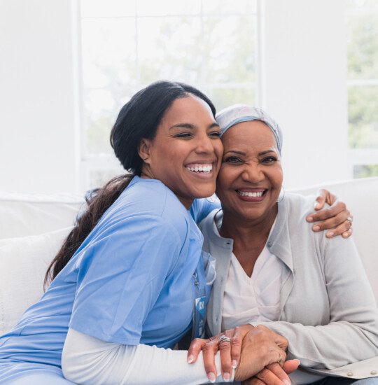 caregiver and elder resident sharing a hug and a smile