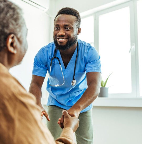 male caregiver holding residents hands and comforting them