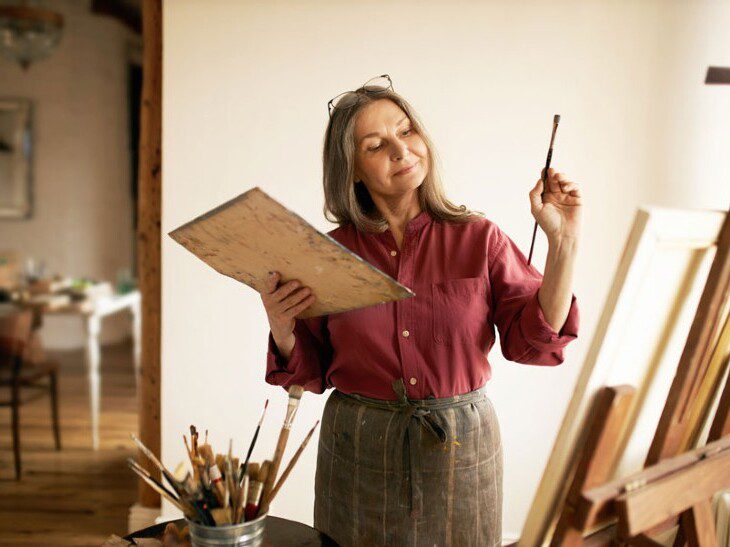 elder woman painting a picture