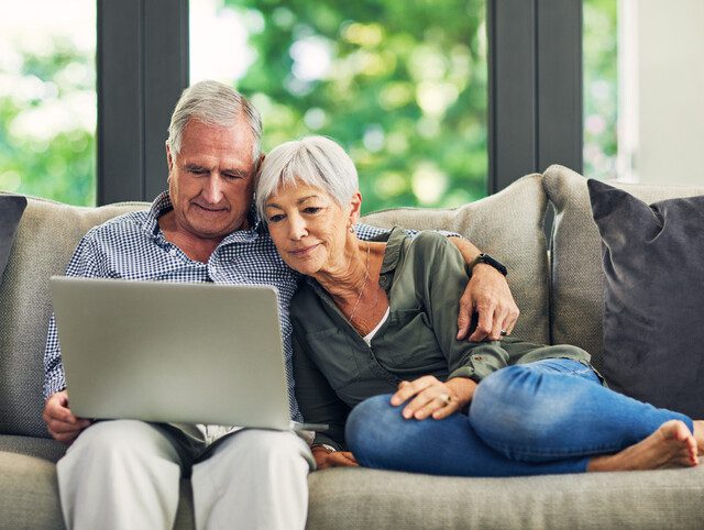 couple using a laptop on the sofa