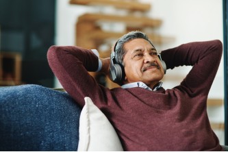 male resident smiling while listening to music on his headphones