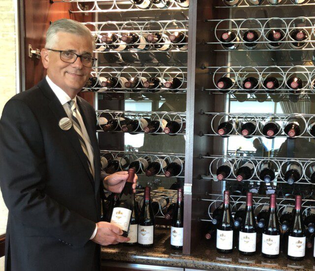 gentleman showing off the impressive wine rack at The Stayton at Museum Way
