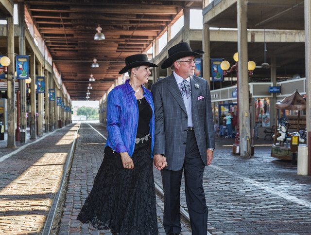 A senior cowboy and cowgirl dressed up in their Sunday clothes walk down at the Stockyards in Dallas, Texas.