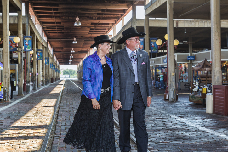 A senior cowboy and cowgirl dressed up in their Sunday clothes walk down at the Stockyards in Dallas, Texas.