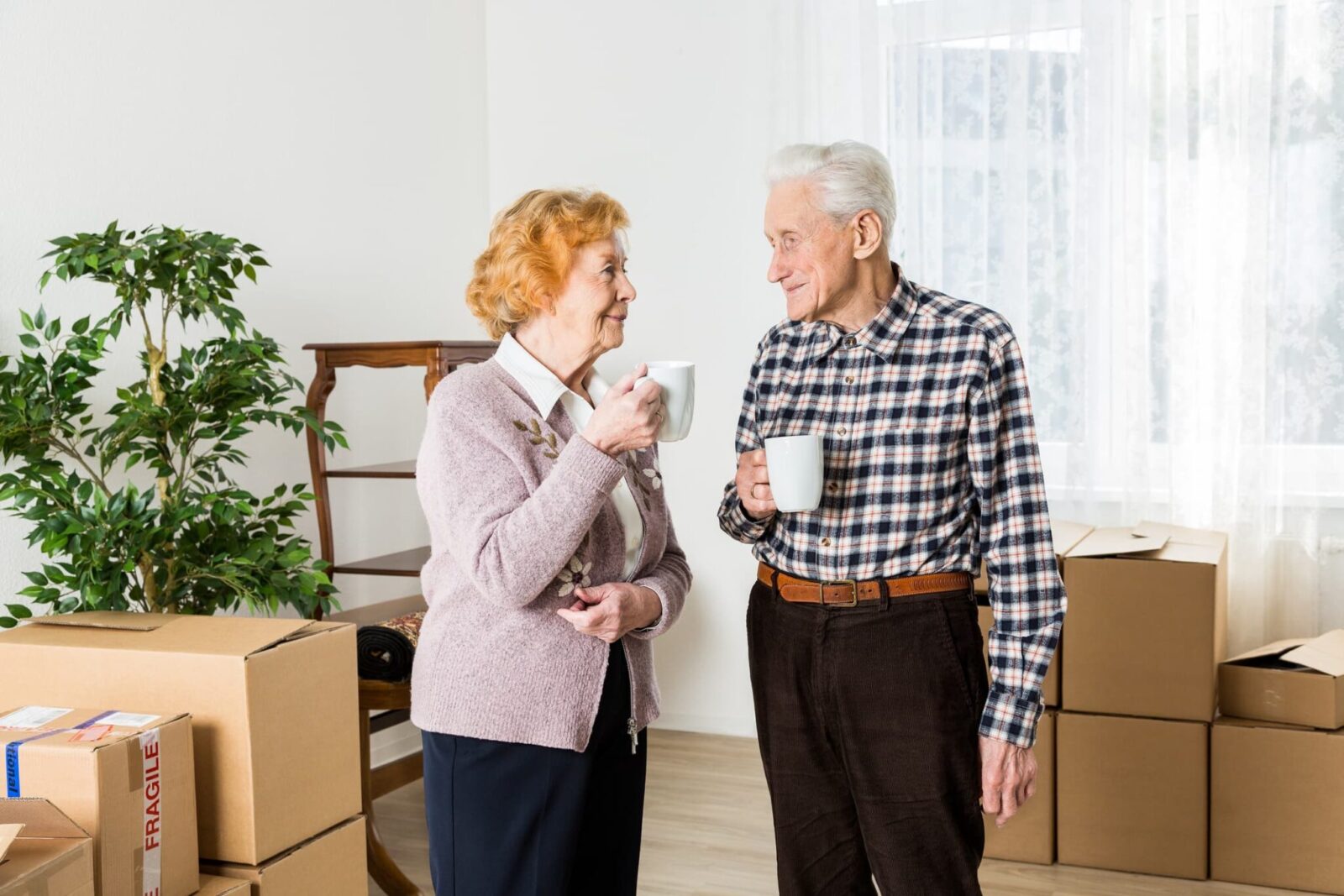 two residents enjoying some coffee together before they start unpacking boxes