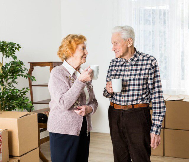 two residents enjoying some coffee together before they start unpacking boxes