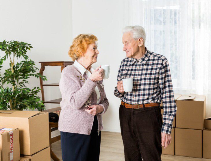 two residents enjoying some coffee together before they start unpacking boxes