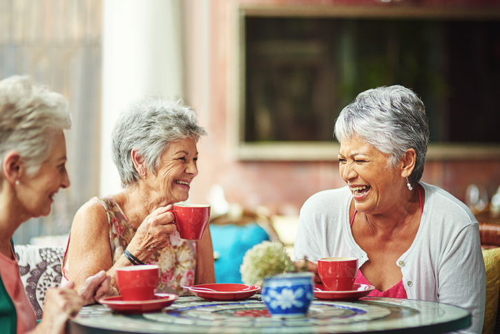 group of elderly friends having coffee together