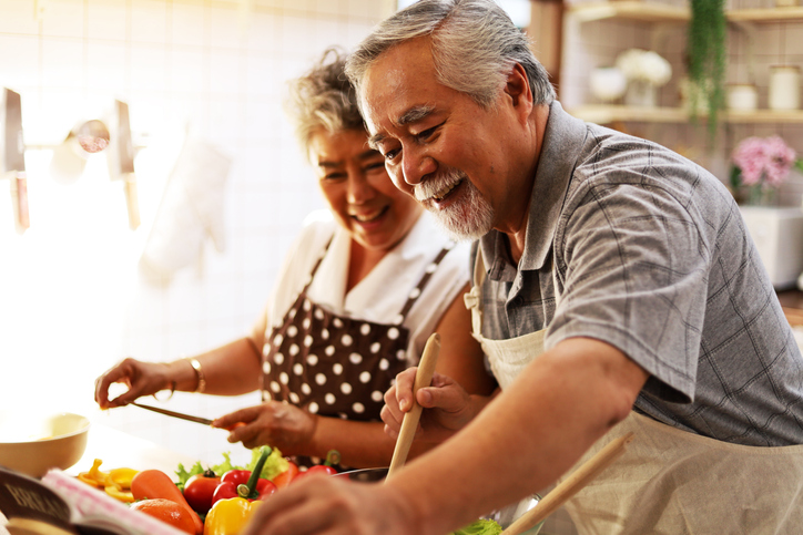 couple having fun in kitchen with healthy food for working from home