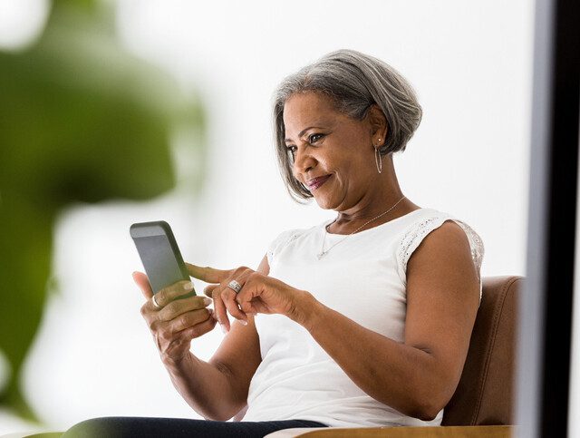 senior woman smiles while video chatting with her grandchildren