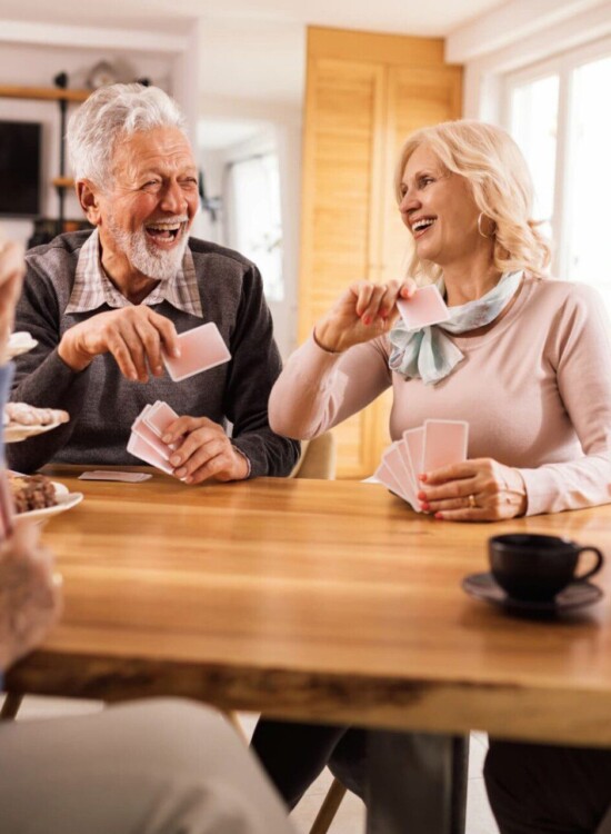 Four friends playing cards and sharing laughs.