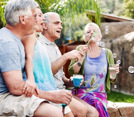 Group of seniors blowing bubbles outside