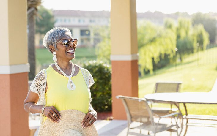 Senior woman happily smiling while outside.