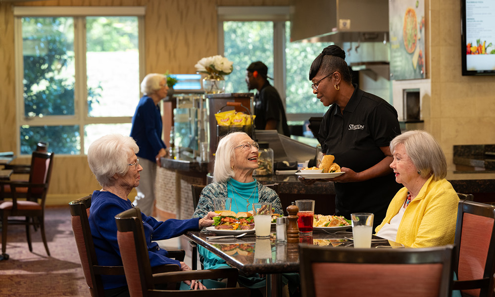 three elderly woman having dinner together.