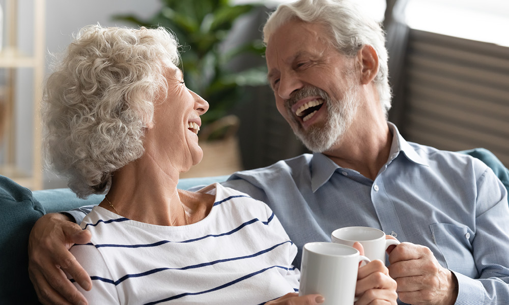 smiling elderly couple drinking coffee together.