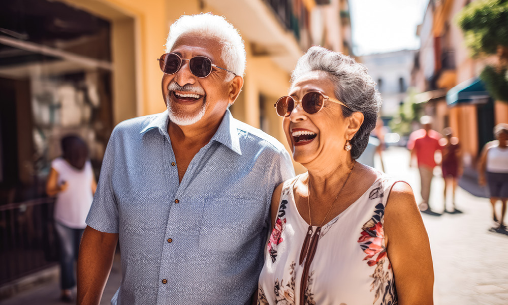 Senior couple smiling while walking down a street.