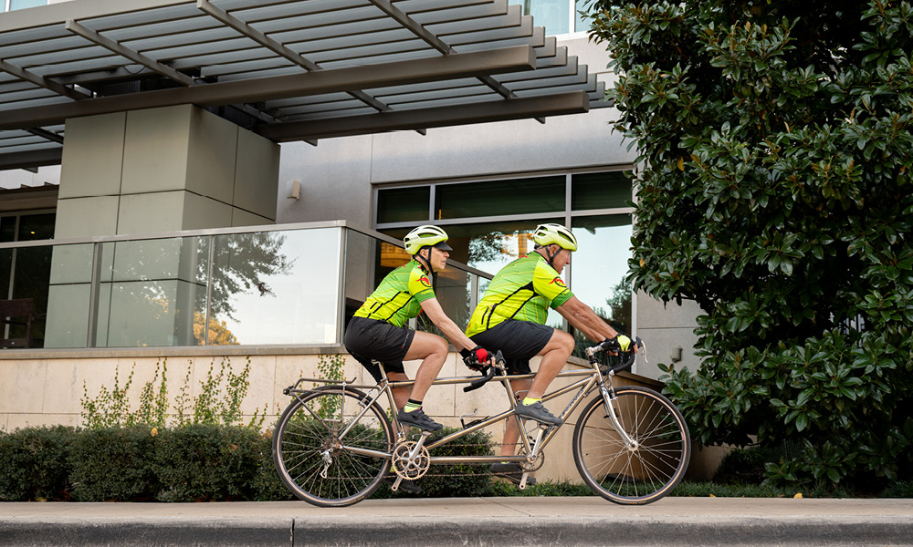 Elderly couple riding a bike together.